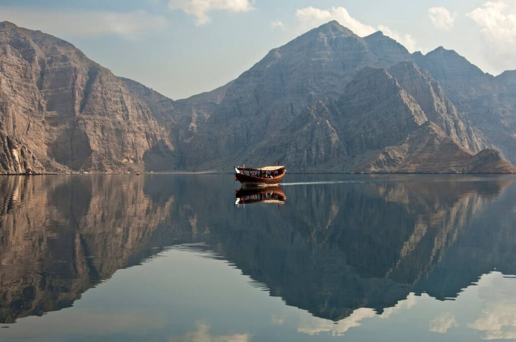 Traditional dhow sailboat moored in a bay during a cruise in the Khor Ash Sham Fjord, Musandam, Sultanate of Oman- Top 10 Tourist Attractions in Oman. Learn How to Save Money on a Cruise Trip?