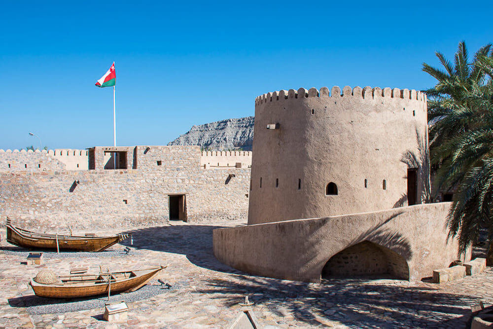 Ancient stone towers and fortified walls of 17th century Khasab Fort Museum in Musandam Oman